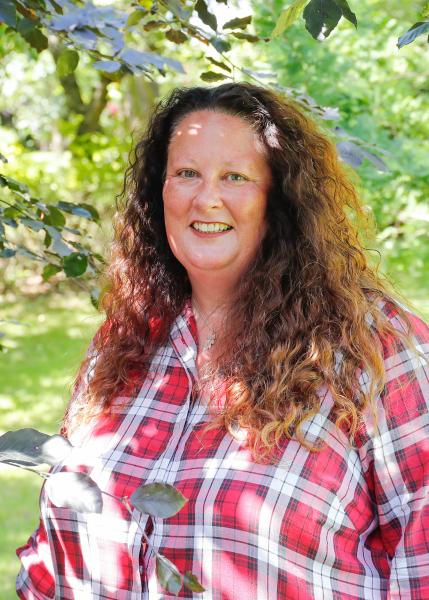 Close up portrait of Beth wearing a red and white checked shirt